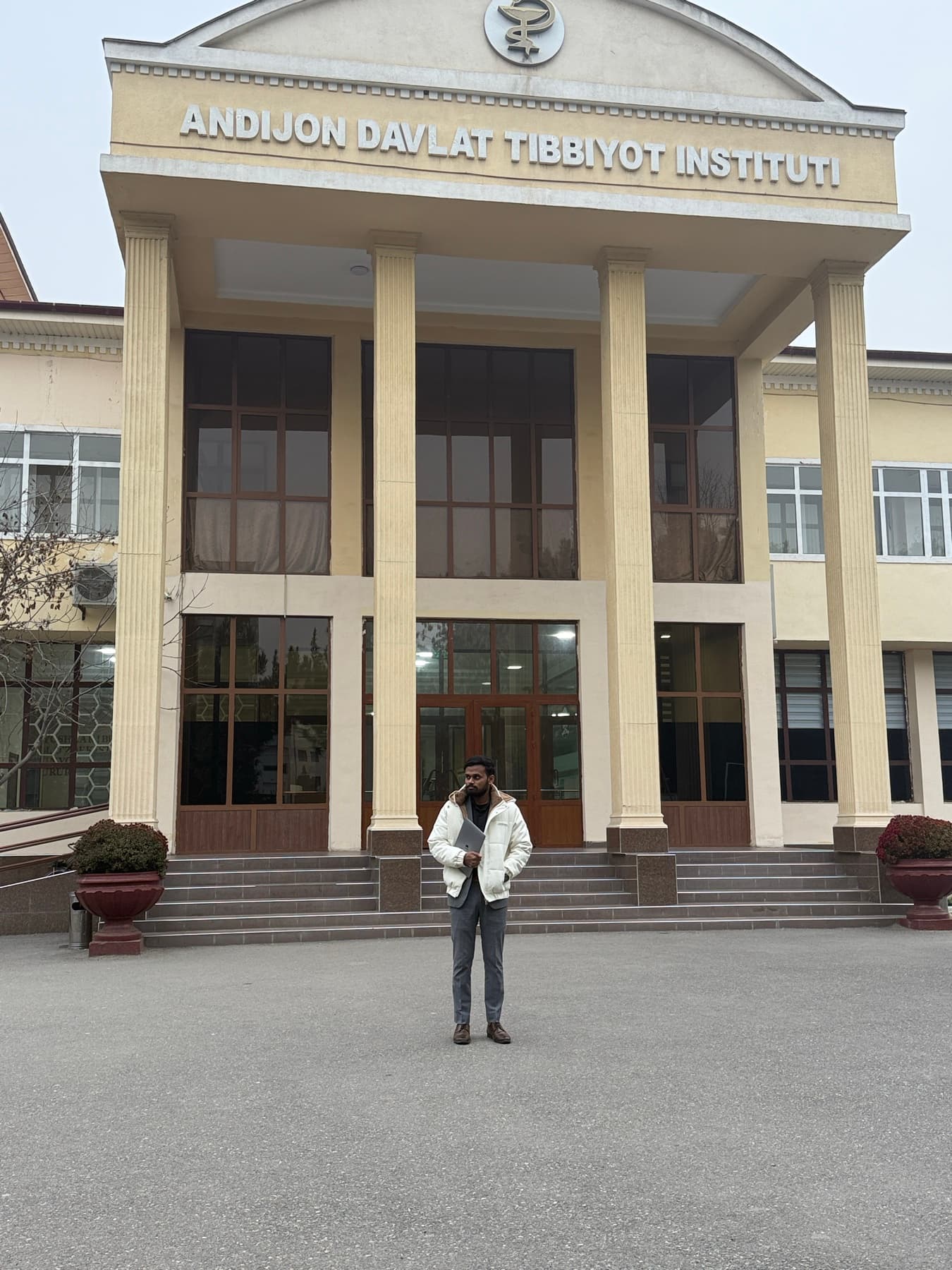 Dr. Ravi standing outside the main building of Andijan State Medical Institute in Uzbekistan.